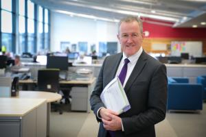 Finance Minister Conor Murphy standing in an office, looking to camera.