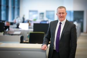 Finance Minister Conor Murphy standing in his office, looking to camera.